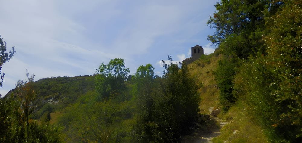 Natural landscape of Tella, Huesca, Spain – The Land of the Witches. The image captures the wild beauty of this Pyrenean village, where dense forests, rocky cliffs, and rolling meadows create a mystical atmosphere.