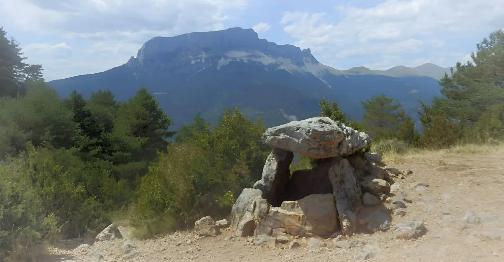 Dolmen in Tella, Huesca, Spain – The Land of the Witches. The image showcases an ancient megalithic tomb set against the dramatic backdrop of the Pyrenees.