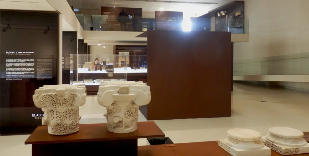 Interior view of the Medina Azahara Museum, Córdoba, Spain. The image showcases a modern exhibition space displaying archaeological artifacts from the 10th-century Umayyad palace-city.