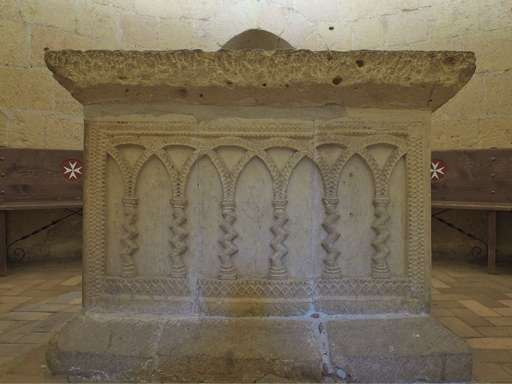 Upper Floor of the Aedicula, Iglesia de la Vera Cruz Segovia. This mysterious altar space—possibly a chapter room or a private oratory—sits atop the central aedicula of the Vera Cruz Church. The prism-shaped altar is framed by interlacing semicircular arches forming pointed shapes, evoking unmistakable Islamic artistic influence. Of particular note are the Solomonic columns, whose spiraling shafts symbolized the ascent to the divine in medieval Christian iconography. Twisting like vines toward heaven, they echo the legendary columns of Solomon’s Temple—deepening the church’s symbolic ties to the Holy Land and its ancient wisdom. Credit: José Luis Filpo Cabana [Edited Photograph]. Licensed under CC BY 3.0. 