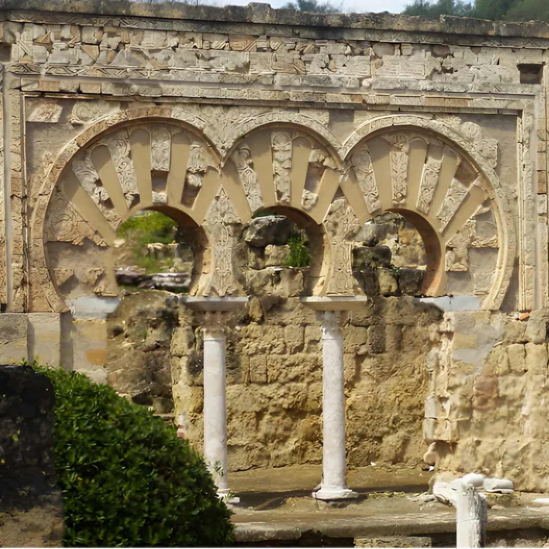 Series of horseshoe arches at Medina Azahara, Córdoba, Spain. The image captures the intricate Islamic architecture of the 10th-century Umayyad palace-city, featuring elegantly carved columns and decorative archways.