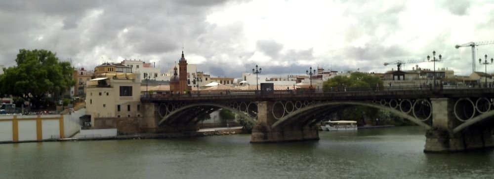 Triana, Seville's Soulful Quarter: A mosaic of vibrant tiles, flamenco rhythms, and riverside reflections, where the essence of authentic Seville dances in the streets.