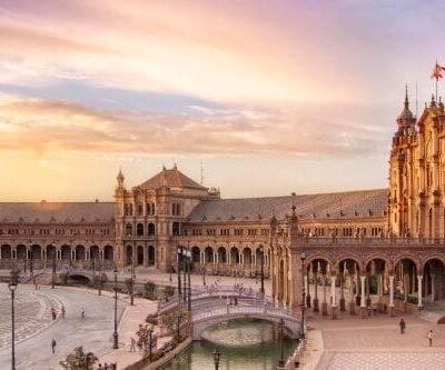 "Panoramic Splendor: Seville's Plaza de España, a majestic semi-circular marvel of architecture, embraces the Andalusian spirit under the Iberian sun.