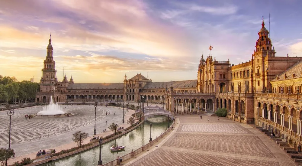 Embracing the Water's Edge: The sweeping curves of Seville's Plaza de España reflect in its tranquil canal, a testament to Spain's rich architectural heritage and cultural tapestry.