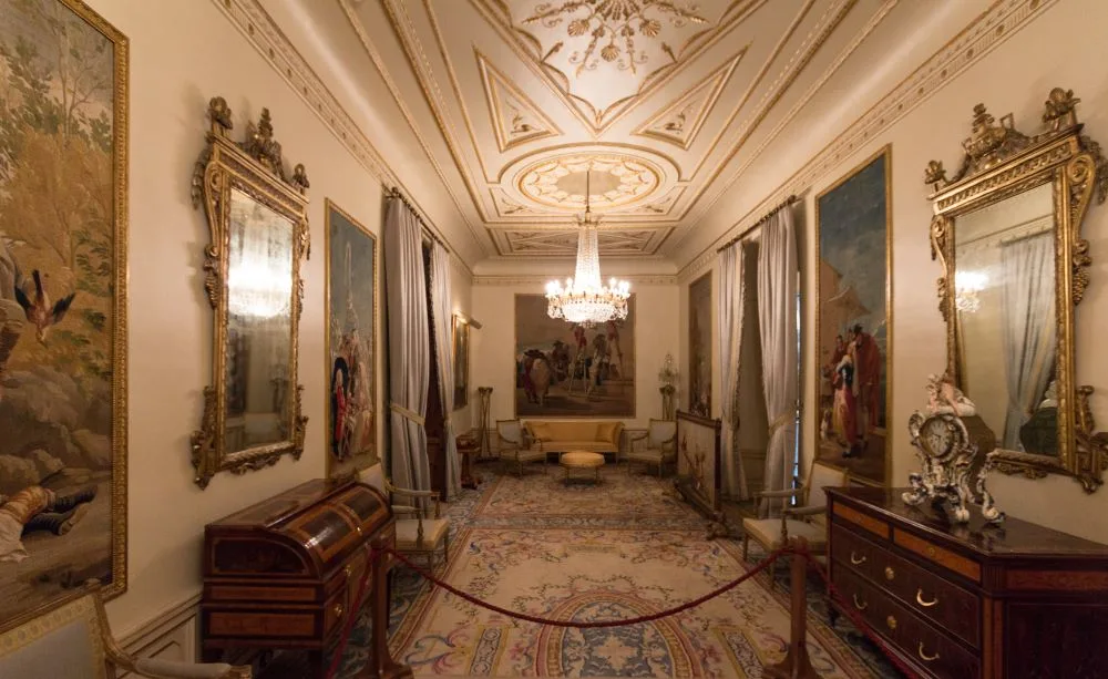 Inside the Goya Hall, admire the Spanish tapestries from the Royal Tapestry Factory of Santa Bárbara in Madrid, based on Francisco de Goya's designs, alongside a custom-made carpet by the III Marquise of Viana, Sofía de Lancaster, and lamps originating from the La Granja de San Ildefonso Palace.