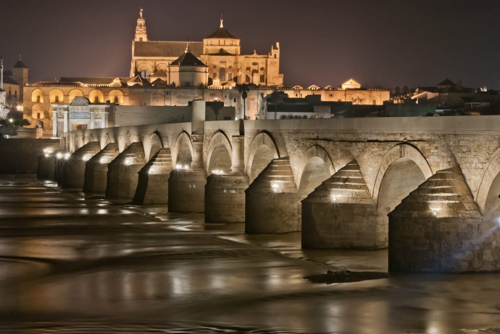 Nighttime Elegance: The Roman Bridge of Córdoba, a Historic Silhouette Against the Evening Sky.