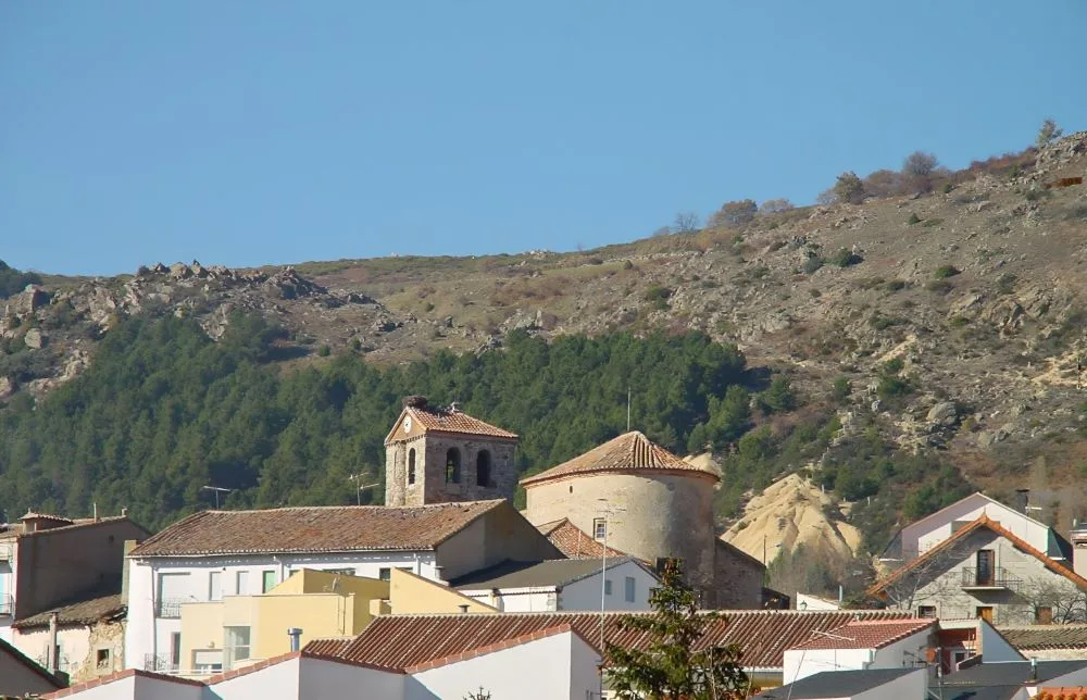 A breathtaking view of Bustarviejo: The picturesque village nestled in the rolling hills of the Sierra de Guadarrama, seen from a distance.