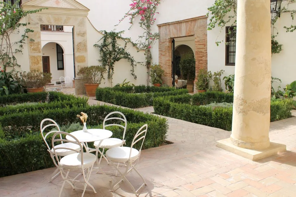 Patio during the Festival of the Patios, Jewish Quarter in Córdoba, Spain [Edited Photograph]. Credit: Nicolas Vollmer. Licensed under CC BY 2.0.