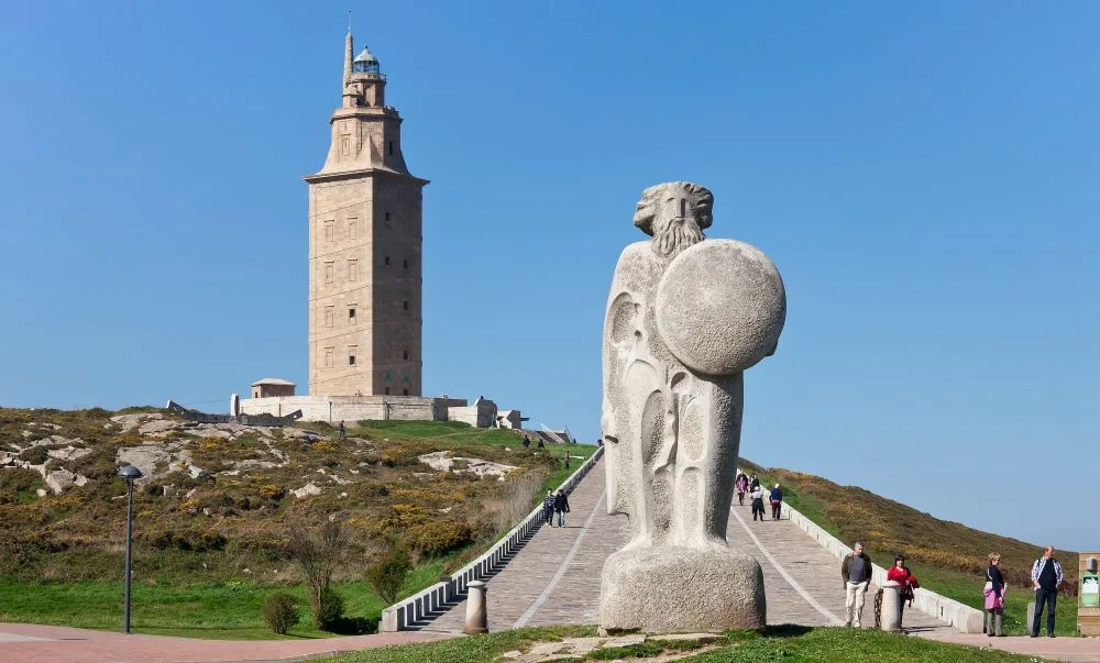 The Tower of Hercules, an ancient Roman lighthouse in A Coruña, Galicia, Spain, surrounded by lush greenery and the Atlantic Ocean. A prominent example of Roman ruins in Spain, this UNESCO World Heritage site showcases the enduring legacy of Spanish Roman ruins.