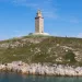 The Tower of Hercules in A Coruña, Galicia, Spain, a striking example of Roman ruins in Spain, stands tall against a vibrant blue sky. This Spanish Roman ruin, a UNESCO World Heritage Site, is the oldest functioning lighthouse in the world, showcasing the architectural ingenuity of ancient Rome.