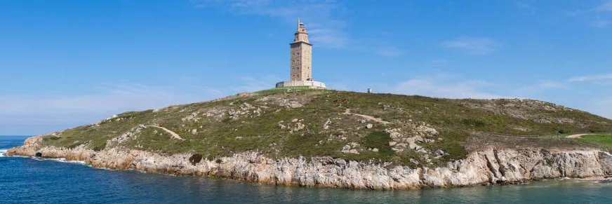 The Tower of Hercules in A Coruña, Galicia, Spain, a striking example of Roman ruins in Spain, stands tall against a vibrant blue sky. This Spanish Roman ruin, a UNESCO World Heritage Site, is the oldest functioning lighthouse in the world, showcasing the architectural ingenuity of ancient Rome.