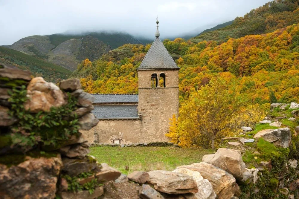 The Iglesia del Monasterio de San Pedro de Montes in Montes de Valdueza, Spain, a historic monastery church surrounded by lush landscapes, reflecting centuries of religious and architectural heritage