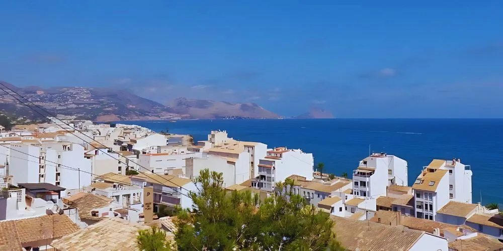 A picturesque view of Altea, Alicante, Spain, showcasing its whitewashed houses, cobblestone streets, and Mediterranean charm with a stunning coastal backdrop.