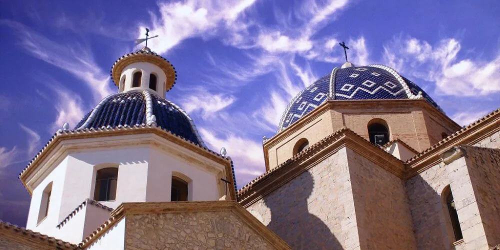 A stunning view of the Church of the Virgen del Consuelo in Altea, Spain, showcasing its iconic blue domes and Mediterranean charm.