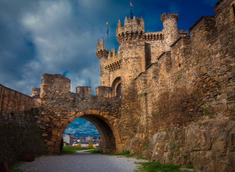 A photograph of the Templar Castle in Ponferrada, León, Spain, showcasing its medieval stone walls, defensive towers, and arched entrance. This historic fortress, originally constructed by the Knights Templar, remains a key architectural and cultural landmark along the Camino de Santiago.