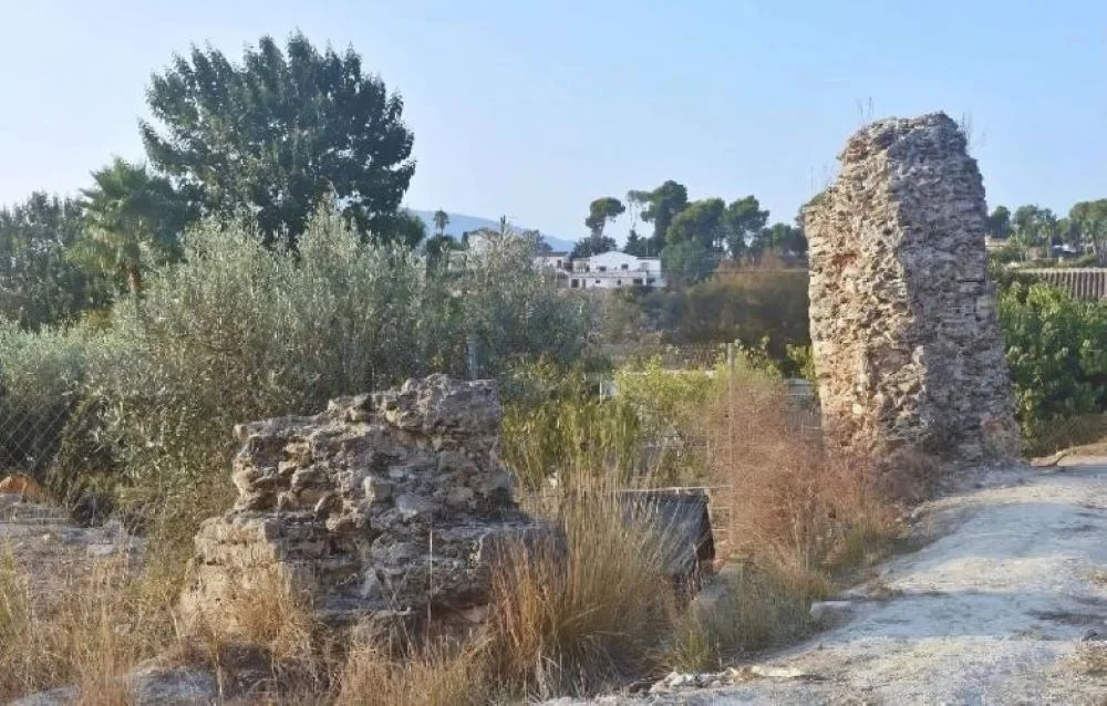 A historic Roman aqueduct in Partida Els Arcs, Altea, Spain, featuring well-preserved stone arches set against a rugged natural landscape.