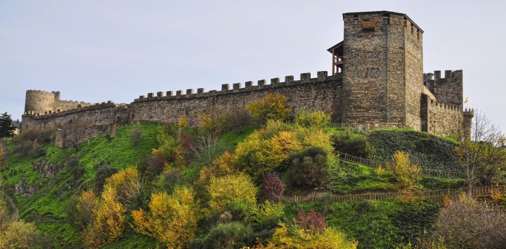 A photograph of the Templar Castle in Ponferrada, León, Spain, showcasing its well-preserved medieval stone walls, towers, and fortified entrance. This historic stronghold, built by the Knights Templar, is a key landmark along the Camino de Santiago and an important example of military architecture in Spain.