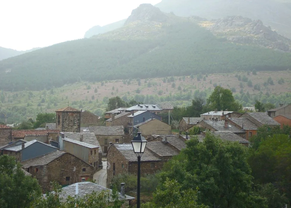 Scenic view of Valverde de los Arroyos, Spain, showcasing its traditional black slate architecture and natural surroundings in the Sierra Norte mountains.