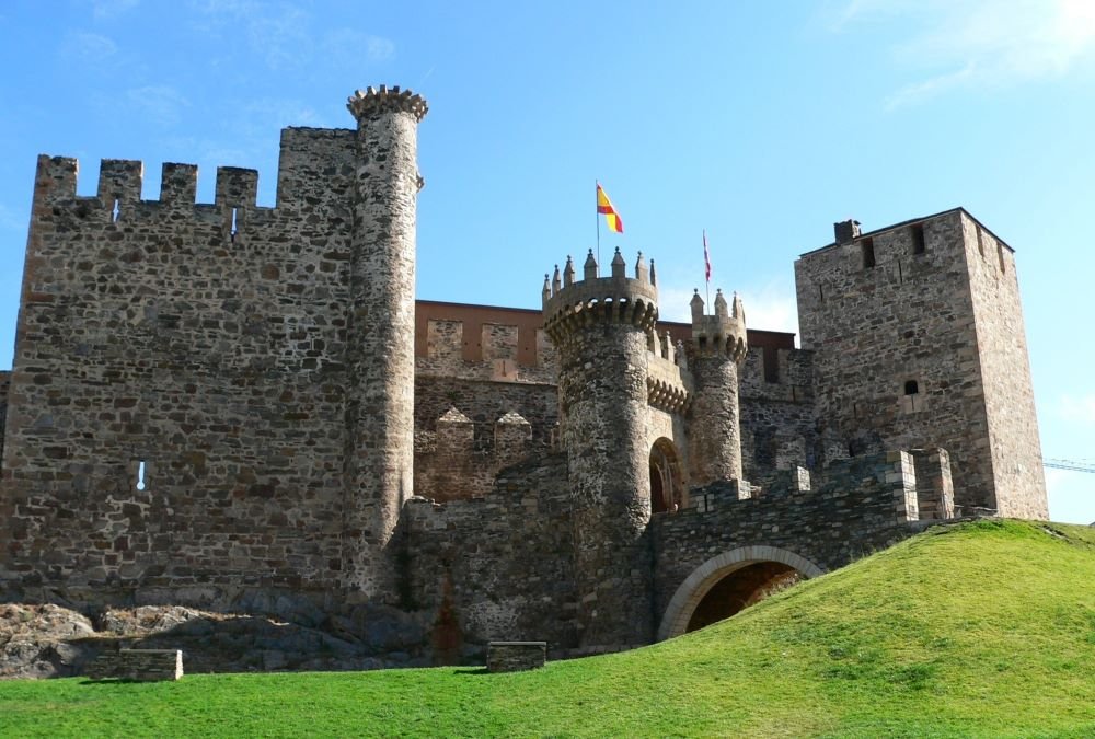 A photograph of the Templar Castle of Ponferrada in León, Spain, featuring its imposing medieval stone walls, towers, and fortified gateways. This historic fortress, built by the Knights Templar, stands as a significant landmark along the Camino de Santiago.